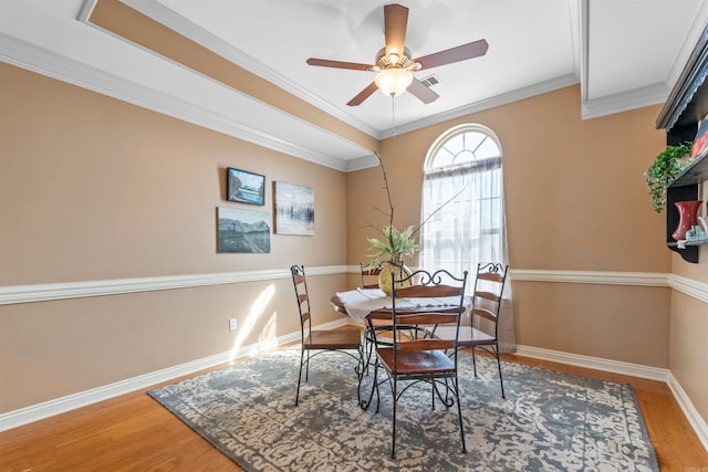 dining room with wood-type flooring, ceiling fan, and crown molding