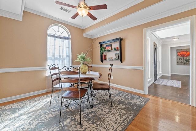 dining room with hardwood / wood-style flooring, ceiling fan, and crown molding