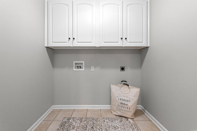 washroom featuring electric dryer hookup, light tile patterned floors, hookup for a washing machine, and cabinets