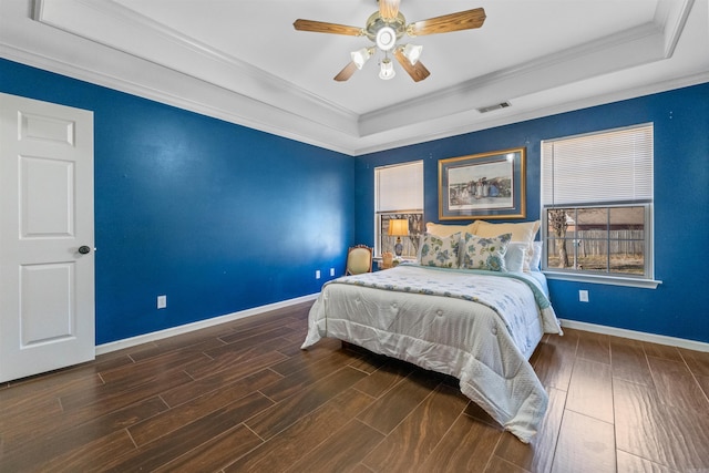 bedroom with crown molding, ceiling fan, wood-type flooring, and a tray ceiling