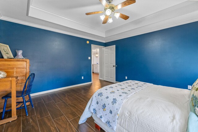 bedroom with crown molding, a tray ceiling, and ceiling fan