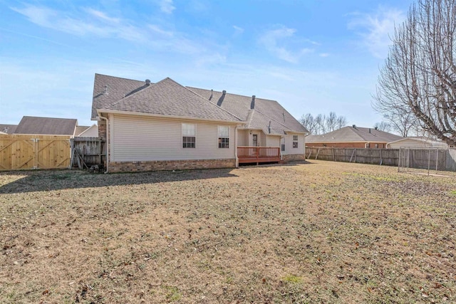 rear view of property featuring a wooden deck and a yard