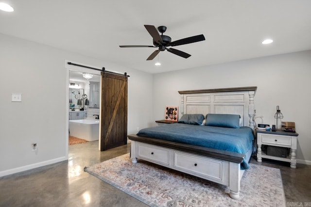 bedroom featuring ceiling fan, ensuite bathroom, and a barn door