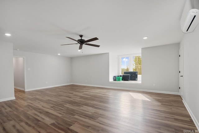 unfurnished living room with a wall mounted air conditioner, dark hardwood / wood-style floors, and ceiling fan