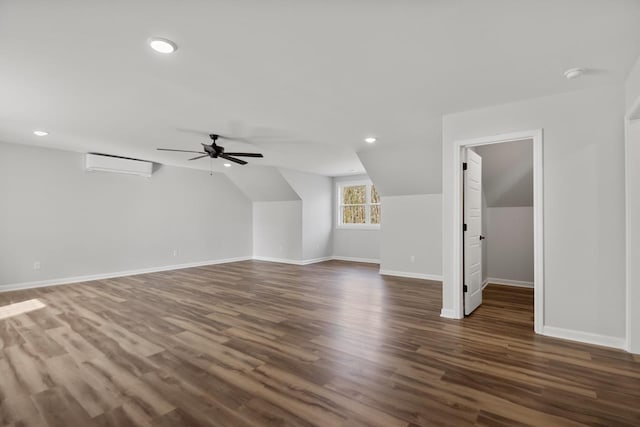 additional living space with lofted ceiling, dark wood-type flooring, a wall unit AC, and ceiling fan