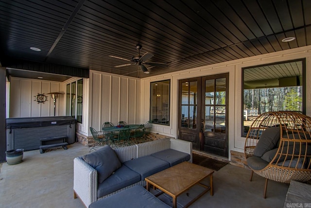 view of patio / terrace featuring a hot tub, an outdoor hangout area, ceiling fan, and french doors