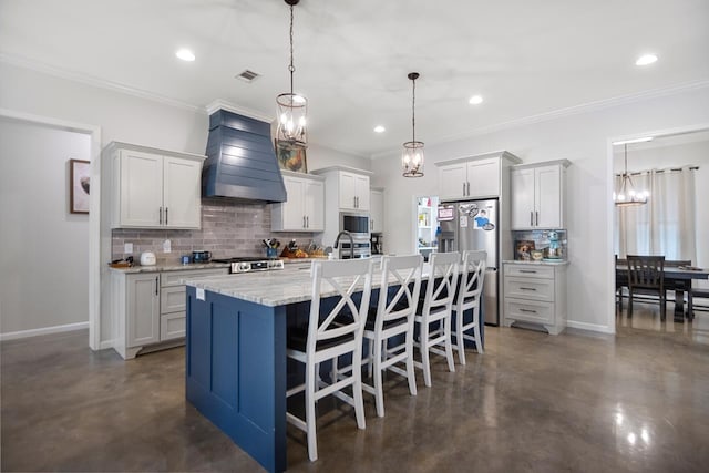 kitchen featuring appliances with stainless steel finishes, a breakfast bar, pendant lighting, custom exhaust hood, and a kitchen island with sink