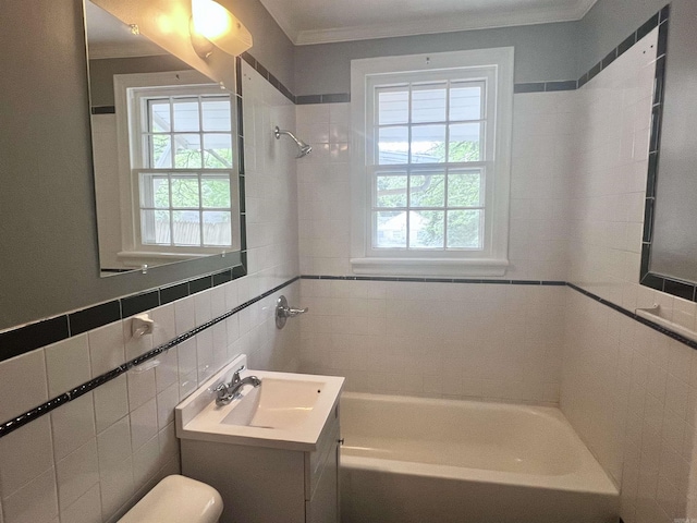 full bathroom featuring tile walls, vanity, ornamental molding, tiled shower / bath, and toilet