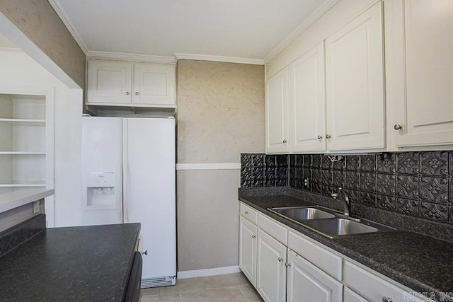 kitchen with sink, white cabinetry, ornamental molding, white refrigerator with ice dispenser, and decorative backsplash