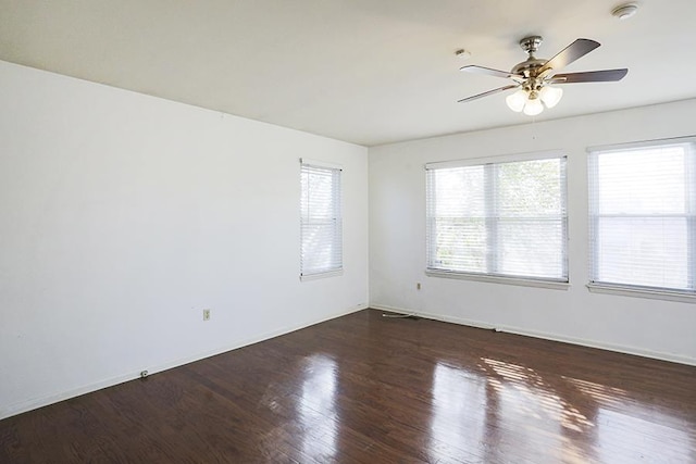 empty room with dark hardwood / wood-style floors and ceiling fan