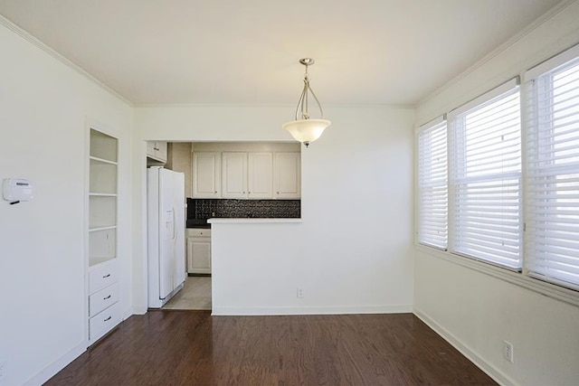 kitchen featuring dark wood-type flooring, backsplash, ornamental molding, decorative light fixtures, and white fridge