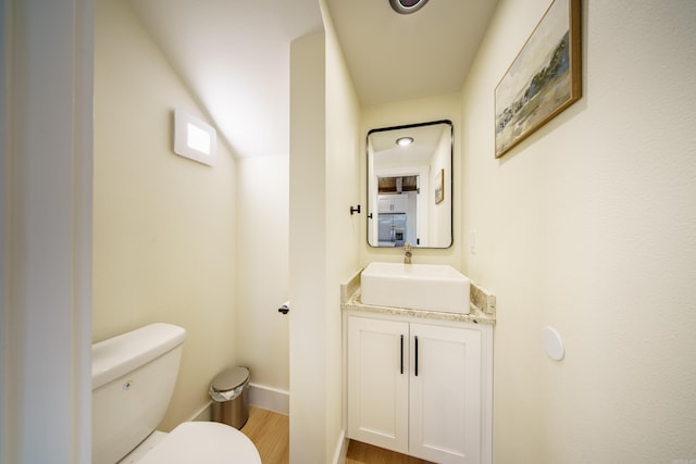 bathroom with hardwood / wood-style flooring, vanity, and toilet