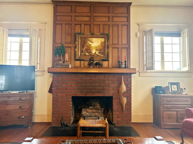 living room with hardwood / wood-style flooring and a brick fireplace