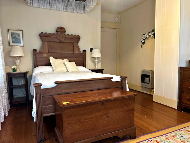 bedroom with ornamental molding, dark hardwood / wood-style floors, and heating unit