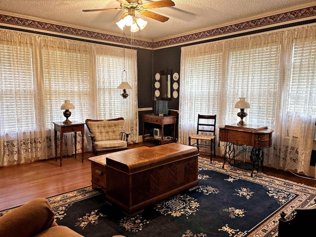 living room featuring ceiling fan, hardwood / wood-style flooring, and a textured ceiling