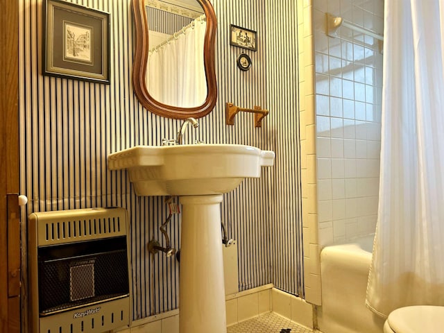 bathroom featuring heating unit and toilet