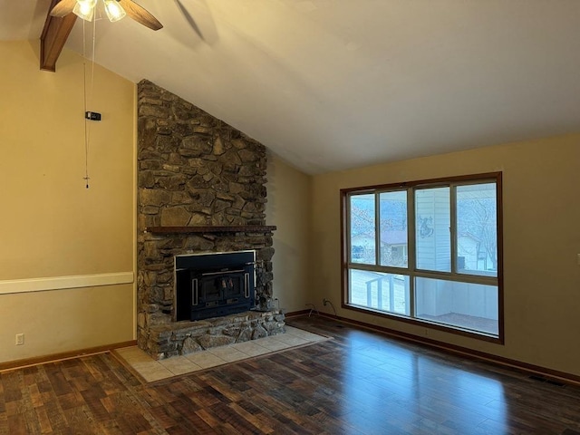 unfurnished living room with wood-type flooring, a stone fireplace, and vaulted ceiling with beams