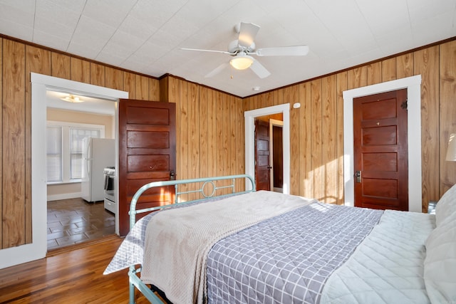 bedroom featuring crown molding, wood-type flooring, and wood walls