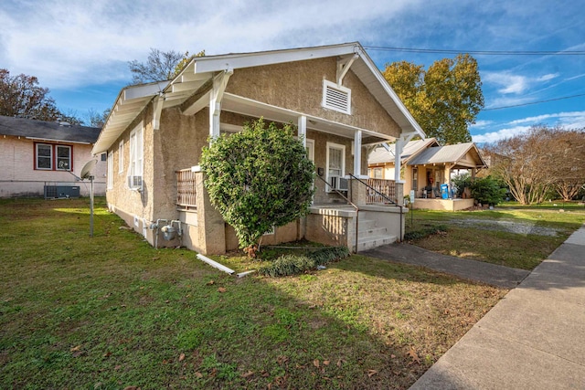 view of front facade featuring cooling unit, a front yard, and a porch