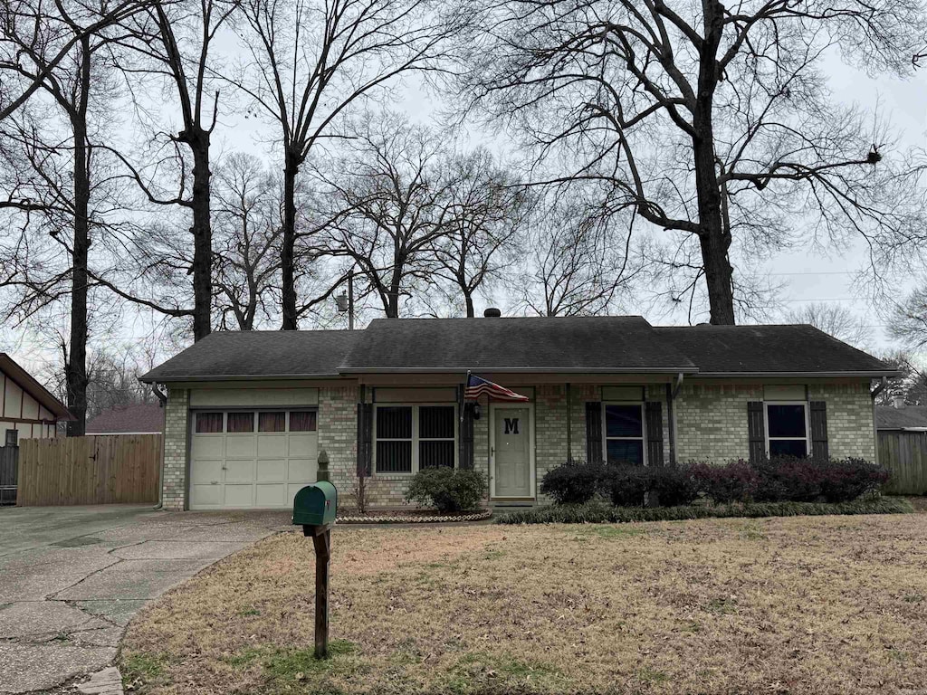 single story home with a garage and a front lawn