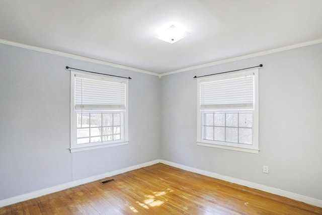 spare room featuring ornamental molding and hardwood / wood-style floors