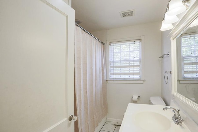 bathroom with sink, curtained shower, tile patterned floors, and toilet