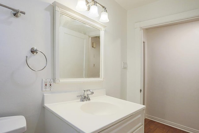 bathroom featuring vanity, wood-type flooring, and toilet