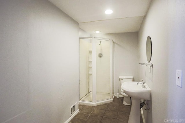 bathroom with tile patterned flooring, toilet, and walk in shower