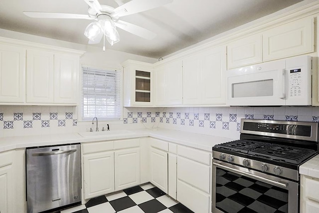 kitchen with sink, ceiling fan, appliances with stainless steel finishes, white cabinets, and decorative backsplash