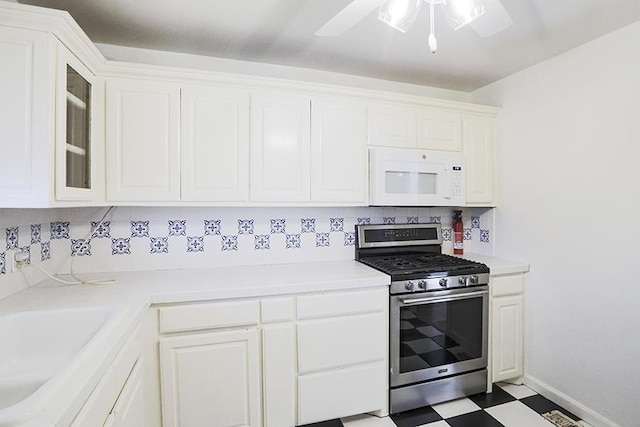 kitchen featuring gas range, white cabinetry, ceiling fan, and sink