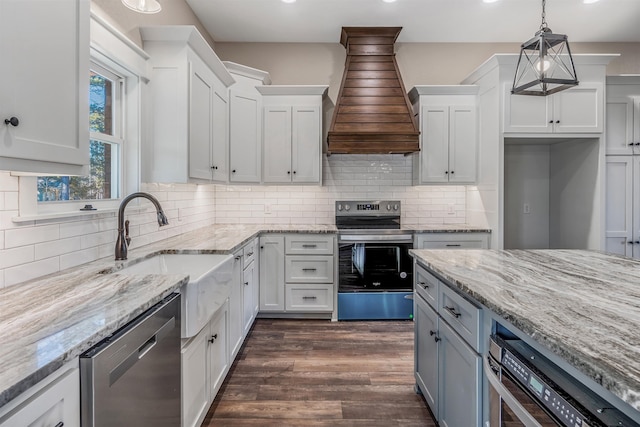 kitchen with appliances with stainless steel finishes, dark hardwood / wood-style flooring, hanging light fixtures, and white cabinets