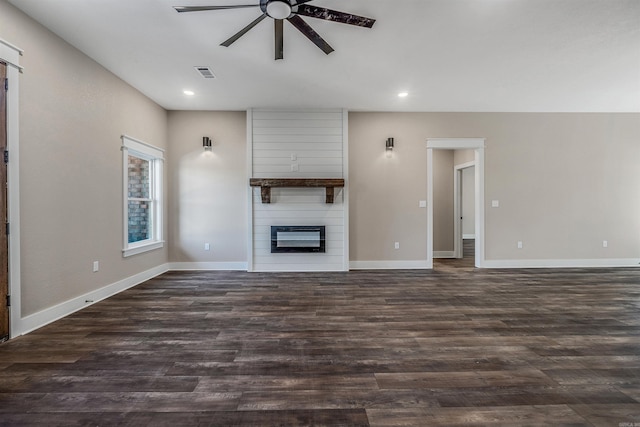 unfurnished living room with ceiling fan, a large fireplace, and dark hardwood / wood-style floors