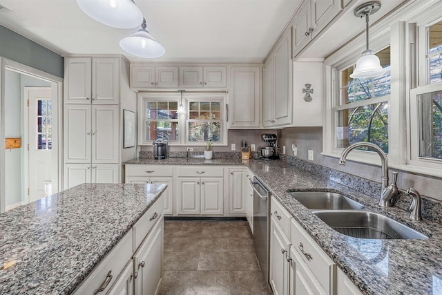 kitchen with dishwasher, white cabinetry, sink, dark stone counters, and hanging light fixtures