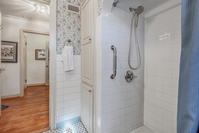 bathroom featuring tile walls, hardwood / wood-style flooring, crown molding, and a shower with shower curtain