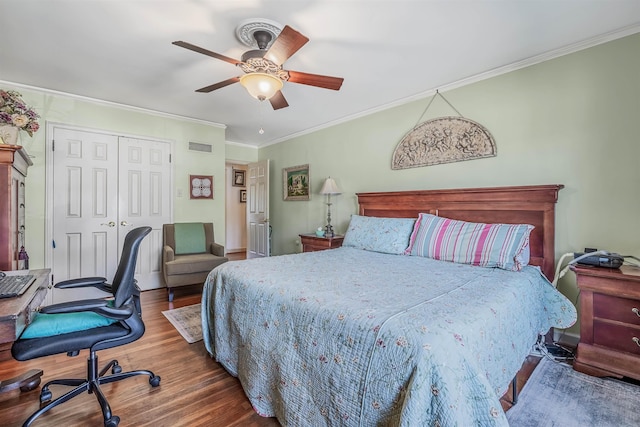 bedroom with hardwood / wood-style flooring, ceiling fan, crown molding, and a closet