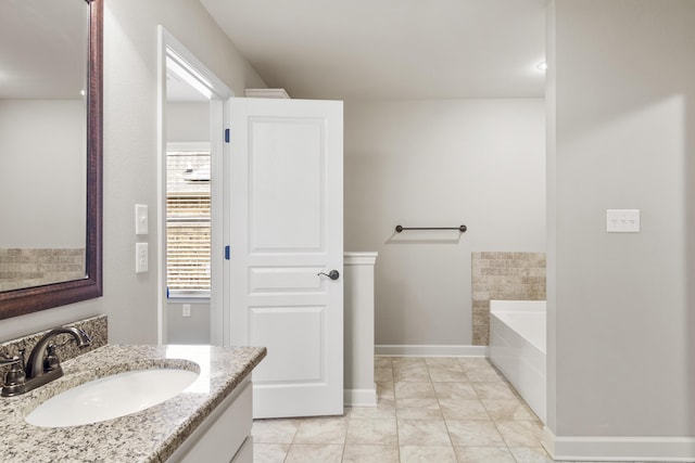 bathroom featuring tile patterned flooring, vanity, and a bathing tub