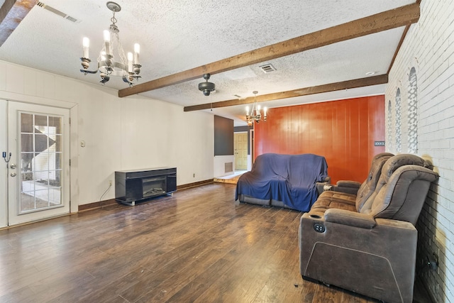 living room featuring dark hardwood / wood-style floors, beam ceiling, a textured ceiling, and a notable chandelier