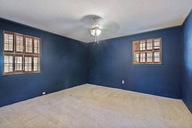 carpeted spare room featuring ceiling fan and a textured ceiling