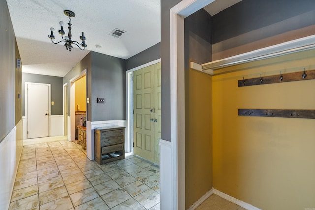 bathroom with a notable chandelier and a textured ceiling