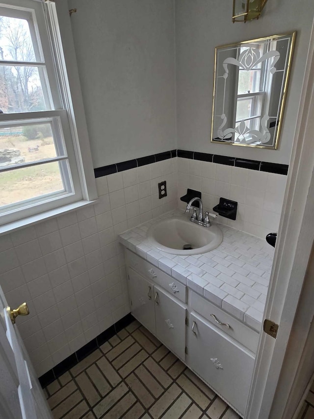 bathroom featuring vanity and tile walls