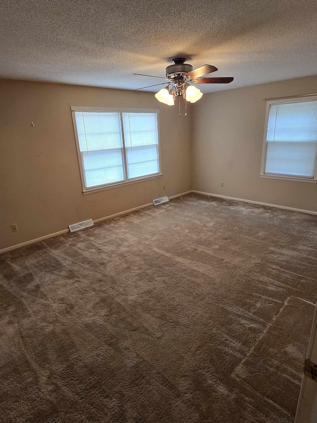 carpeted empty room with ceiling fan and a textured ceiling