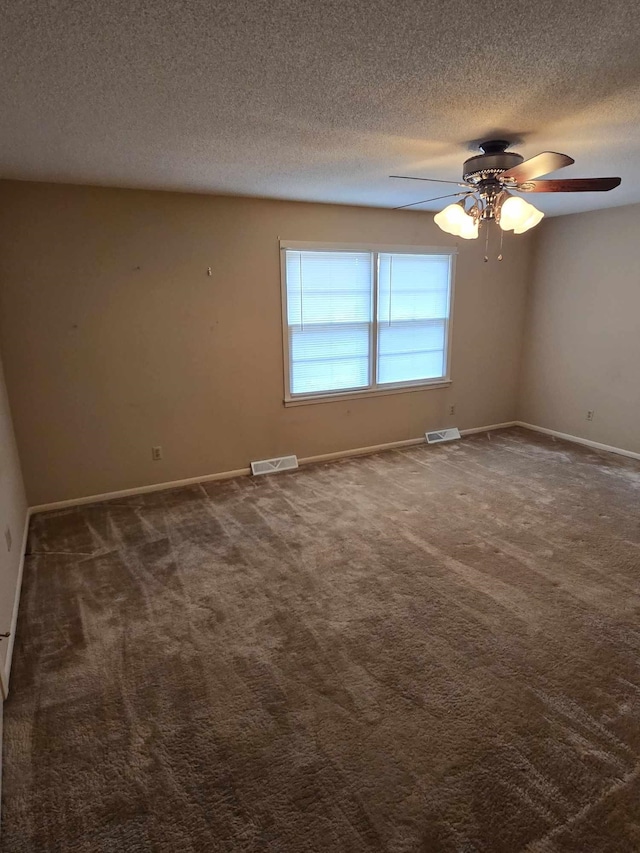 carpeted empty room with ceiling fan and a textured ceiling