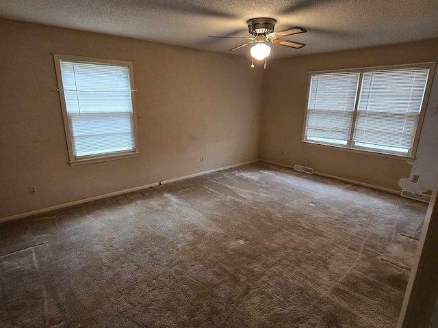 carpeted spare room featuring ceiling fan and a textured ceiling