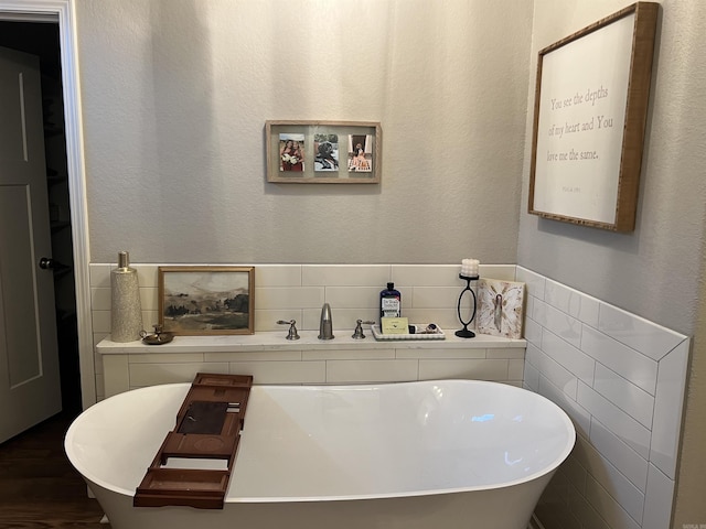 bathroom featuring a bathtub and tile walls