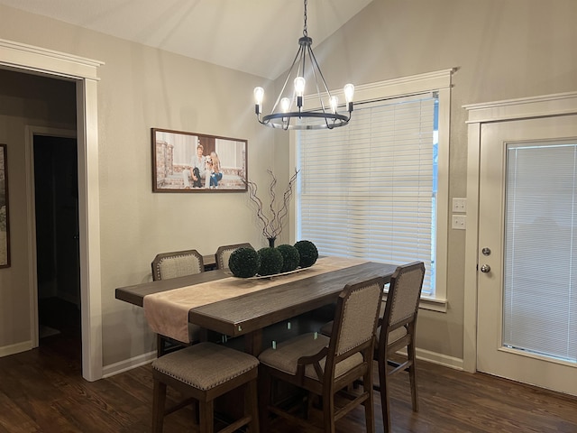 dining space featuring dark wood-type flooring, lofted ceiling, and a notable chandelier