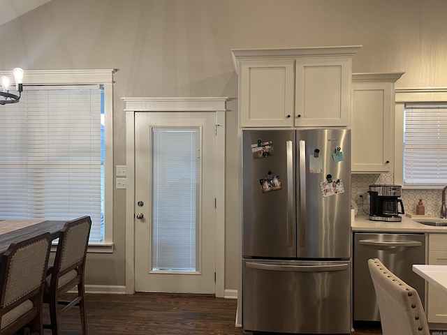 kitchen featuring appliances with stainless steel finishes, white cabinetry, sink, decorative backsplash, and dark wood-type flooring