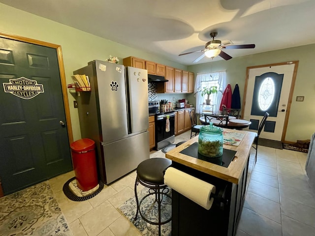 kitchen featuring stainless steel appliances, light tile patterned flooring, and ceiling fan