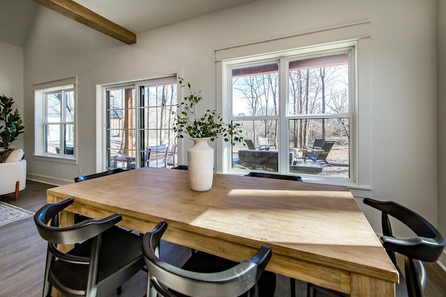 dining space featuring dark wood-type flooring and beam ceiling