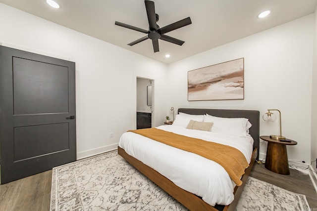 bedroom with wood-type flooring, connected bathroom, and ceiling fan