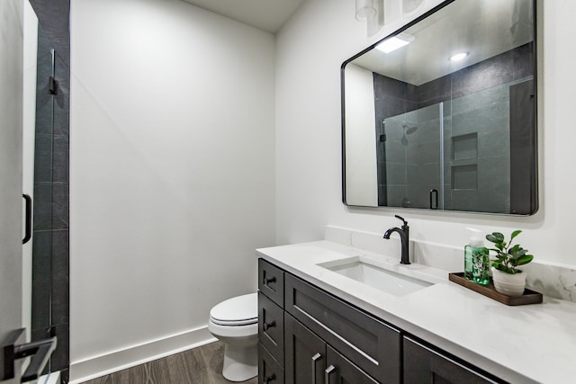 bathroom featuring an enclosed shower, wood-type flooring, vanity, and toilet